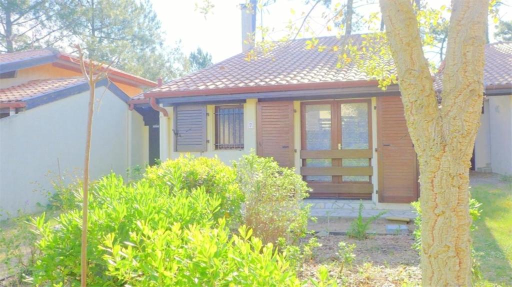 une petite maison avec un porche dans une cour dans l'établissement Réf 210 Seignosse Océan, Villa Patio Classée 3 étoiles au Calme, Proche de la plage et des commerces, à Seignosse