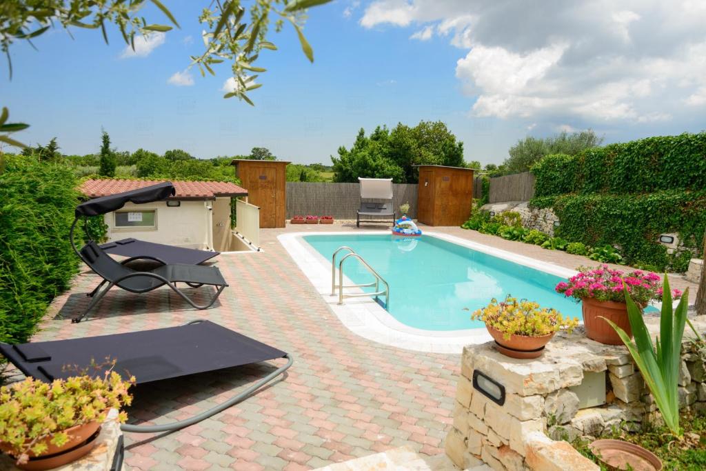 basen ze stołem i krzesłami obok niego w obiekcie HelloApulia - Villa Flora w mieście Noci