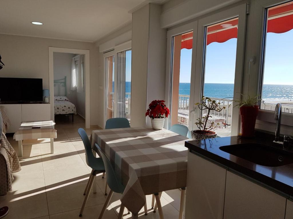 una cucina con tavolo e vista sull'oceano di APARTAMENTO 1 LINEA SAN JUAN DE ALICANTE a El Campello