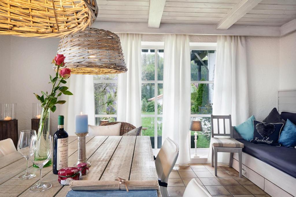a dining room with a wooden table and windows at Ferienhaus Nest in Blaichach
