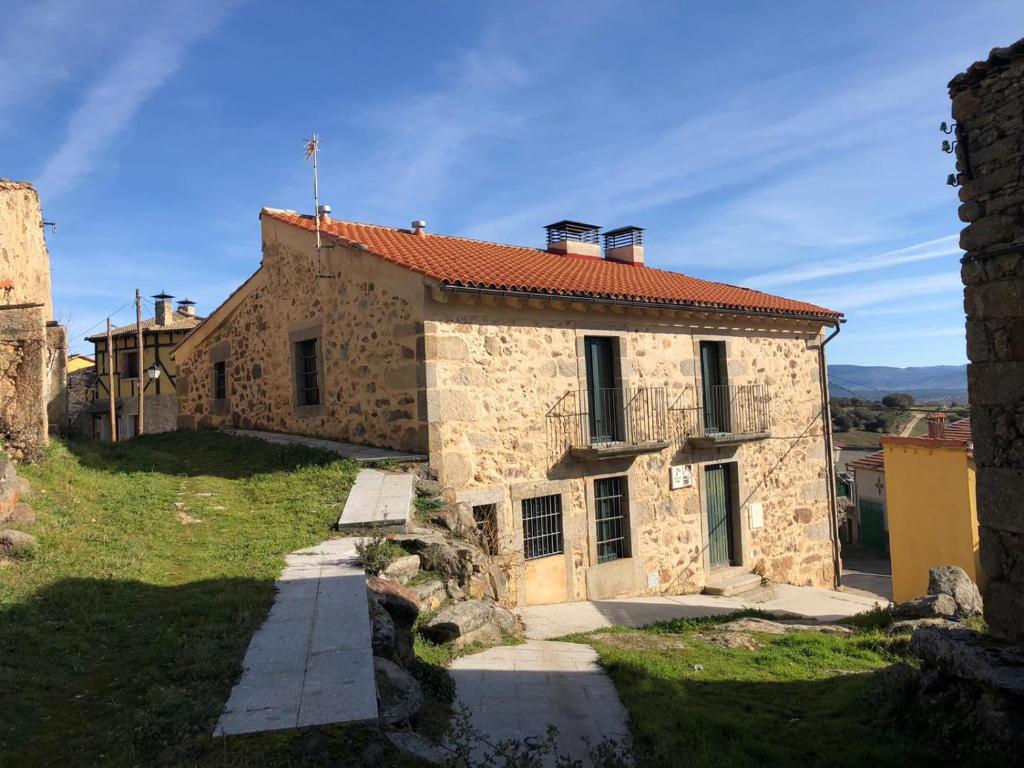 ein Steinhaus mit rotem Dach auf einem Hügel in der Unterkunft Casa Rural Fuente la Bolera in Gilbuena