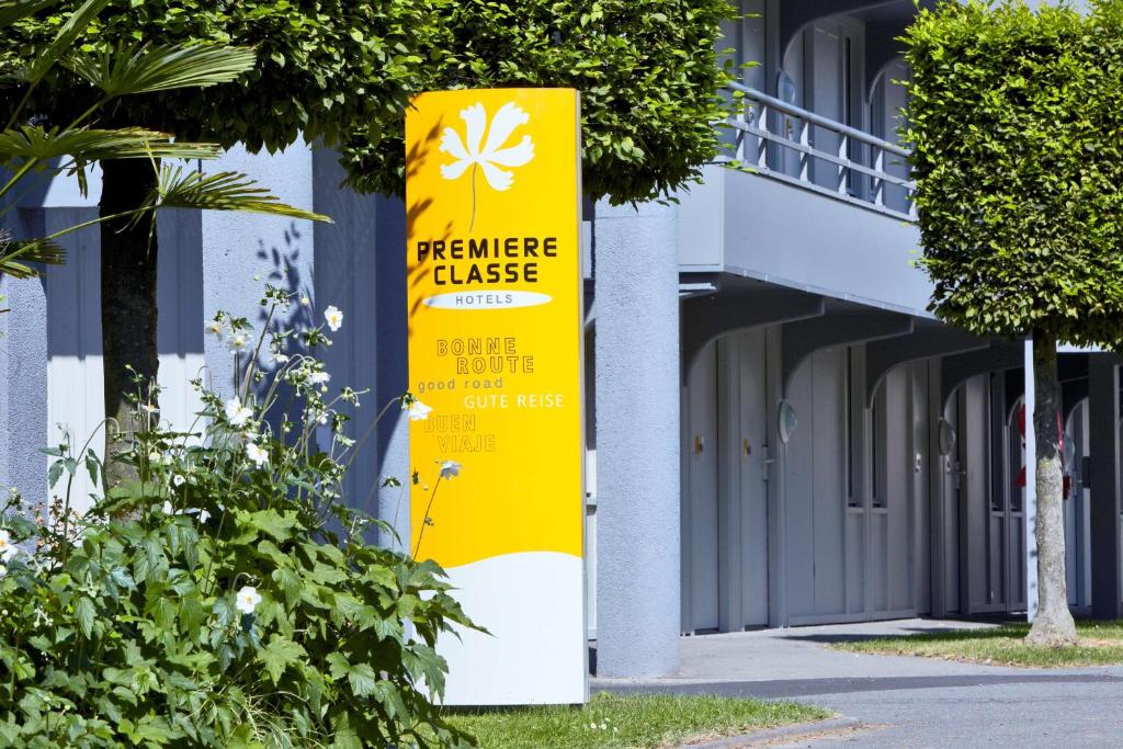 a yellow sign on the side of a building at Premiere Classe Grenoble Nord Moirans in Moirans