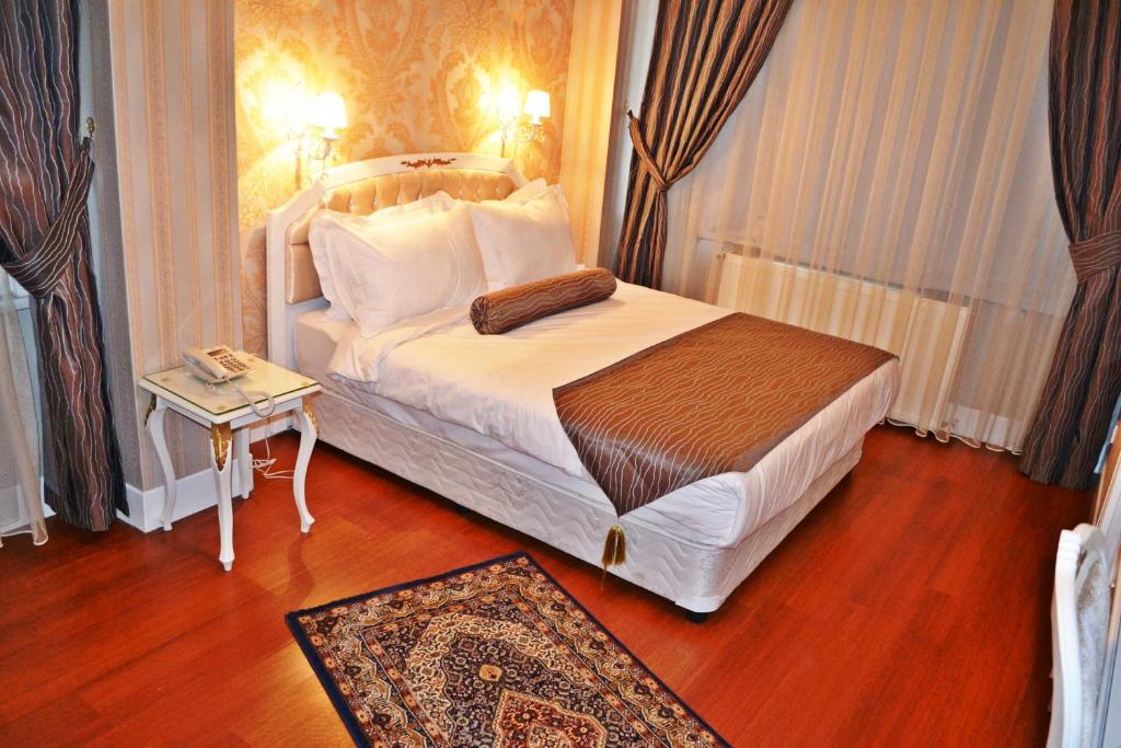 1 dormitorio con 1 cama grande y 1 mesa en Napolyon Apart Hotel Cihangir, en Estambul