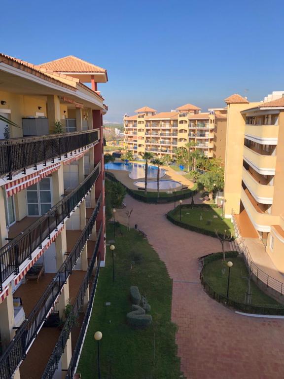 卡耐特蒂貝蘭格的住宿－Urbanización Mar de Canet, 2 dormitorios con piscina comunitaria, garaje y wifi，享有公寓大楼庭院的正面景色