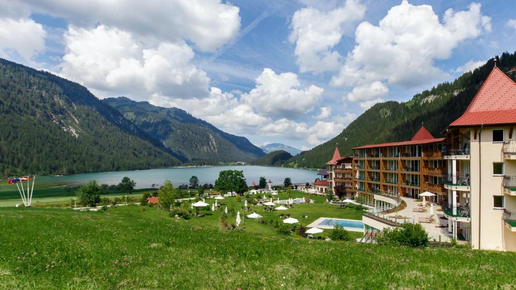 um resort com um lago e montanhas ao fundo em Romantik Resort & SPA Der Laterndl Hof em Haldensee