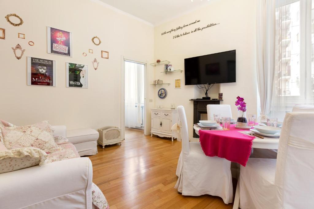 un soggiorno bianco con tavolo e TV di Naviglio Pavese Cosy Apartment a Milano