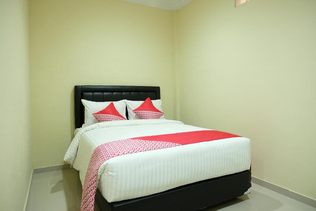a bedroom with a large bed with red pillows at OYO 1149 Hotel Mustika in Tanjungpandan