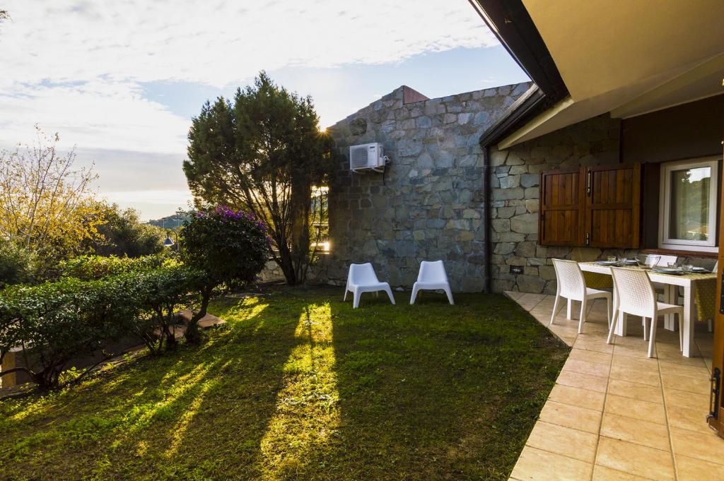 a patio with chairs and a table in a yard at Sa Tirìa in Chia
