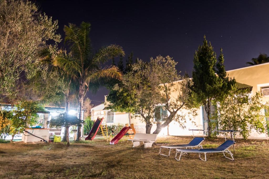 einen Park mit Schaukeln und einer Bank und Bäumen in der Nacht in der Unterkunft B&B Villaggio Regina in Matino