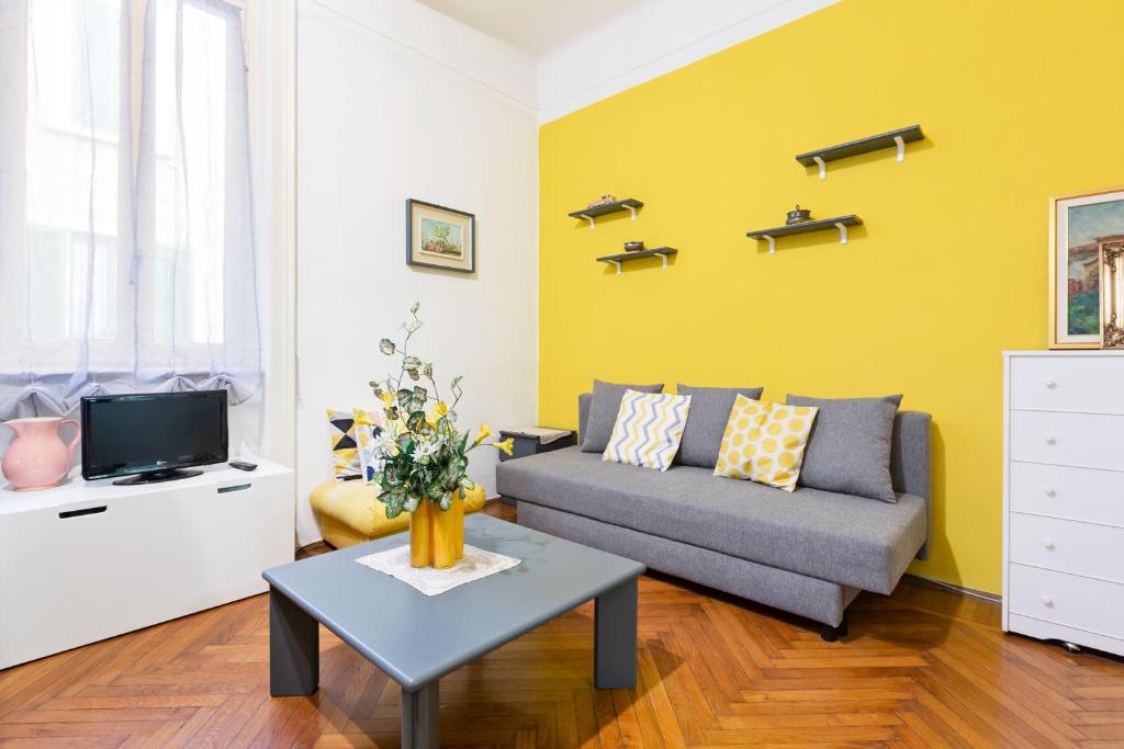 een woonkamer met een bank en een tv bij Loreto Courtyard Apartment in Milaan