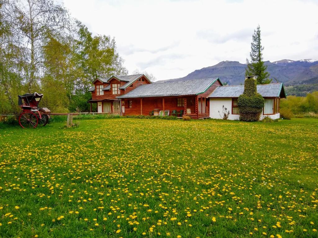 a house with a field of flowers in front of it at Las Vertientes Lodge in San Martín de los Andes