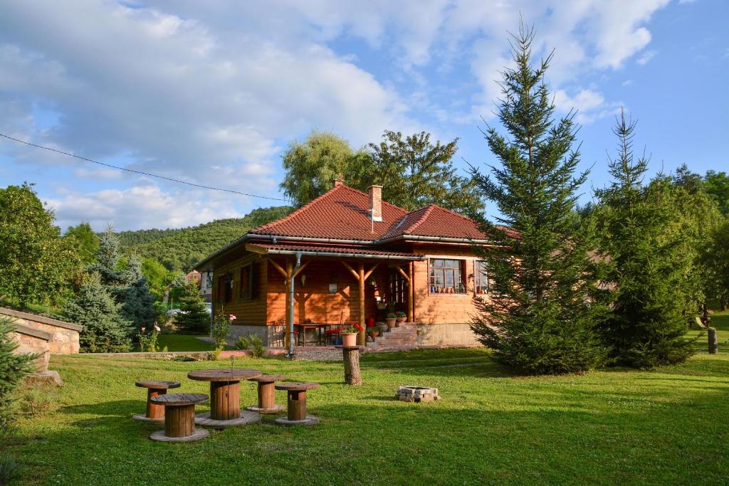 a log cabin with picnic tables in front of it at Halháza vendégház in Sirok