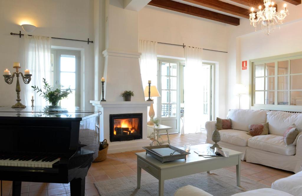a living room with a piano and a fireplace at Mas del Mar in Sant Pere Pescador
