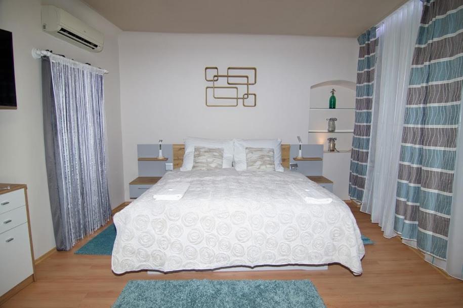 sypialnia z dużym białym łóżkiem w pokoju w obiekcie Soda apartman w Győr