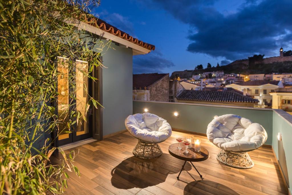 a patio with two chairs and a table on a balcony at Carpe Diem Boutique Hotel in Nafplio