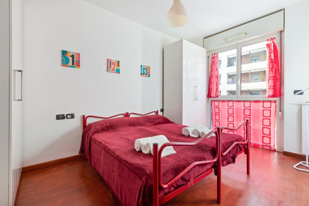 a bedroom with a red bed and a window at Milano-Rubattino Budget Apartment in Milan