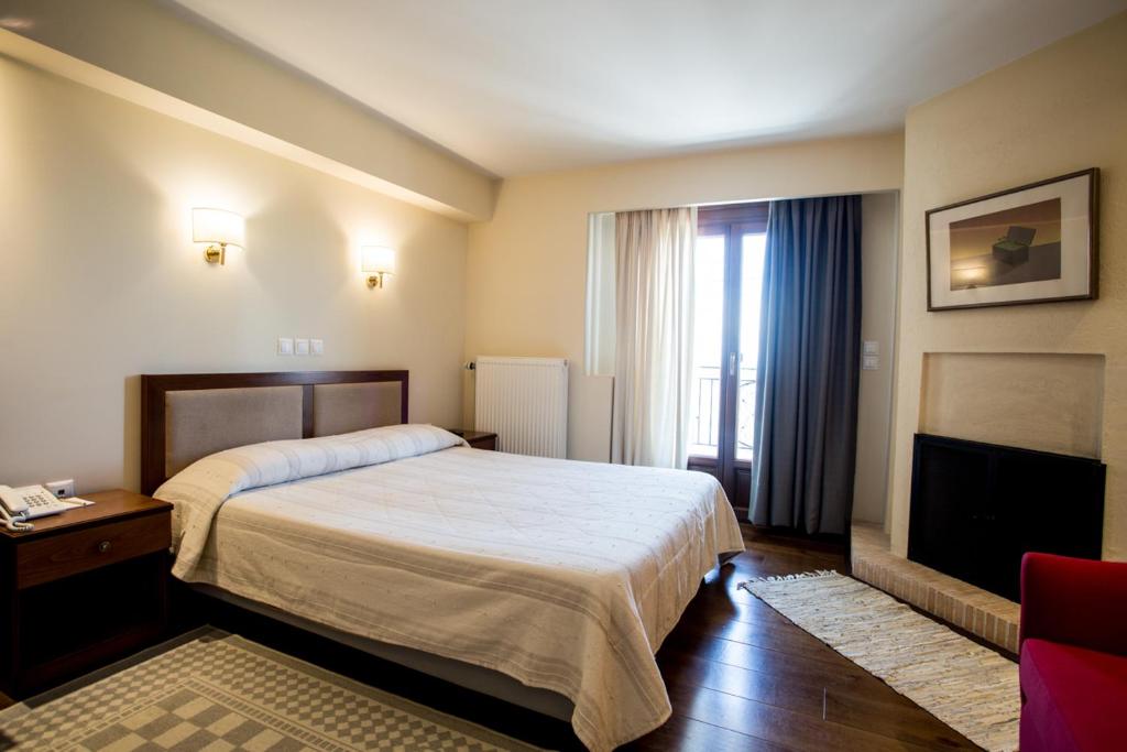 a hotel room with a bed and a television at Ellinon Thea Arachova in Arachova