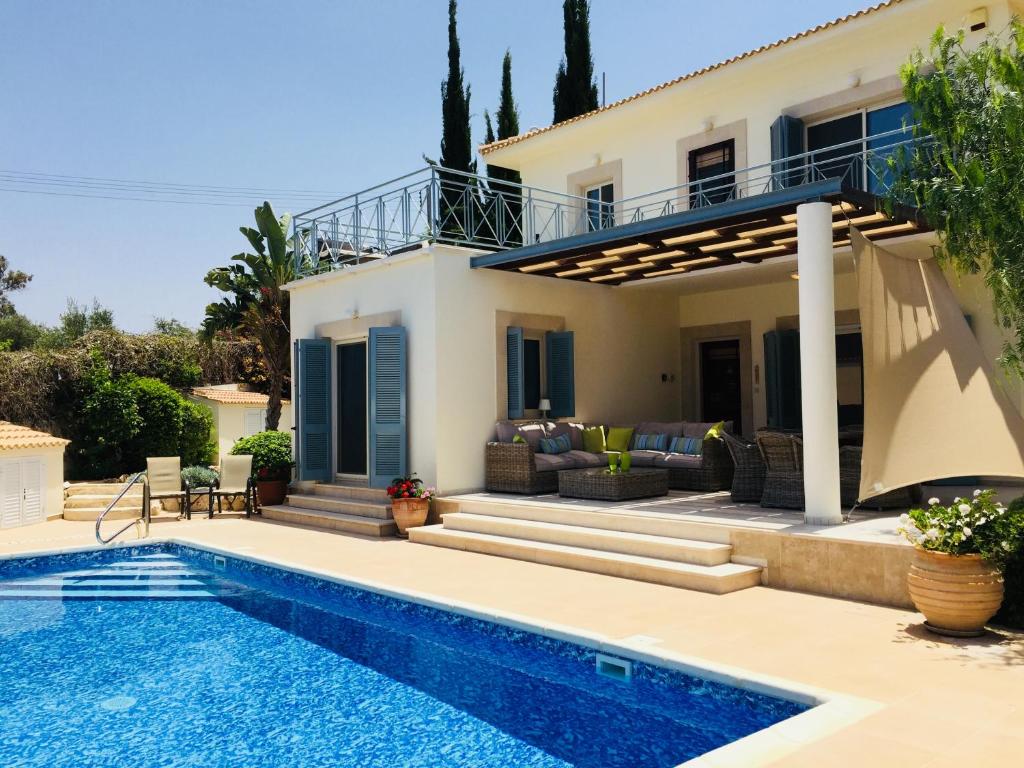 a villa with a swimming pool and a house at Beach villa Gladiolus in Neokhorio