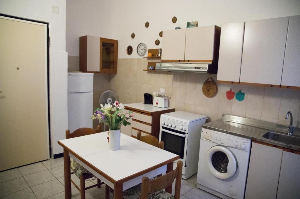 - une cuisine avec une table et des fleurs dans l'établissement Grillo apartment, à Levanto