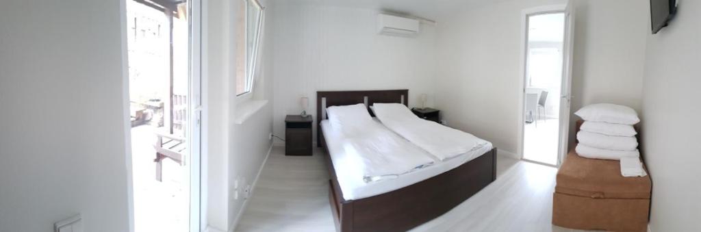 ein weißes Schlafzimmer mit einem Bett und einem Spiegel in der Unterkunft Vila Goda & Vila Roma in Neringa