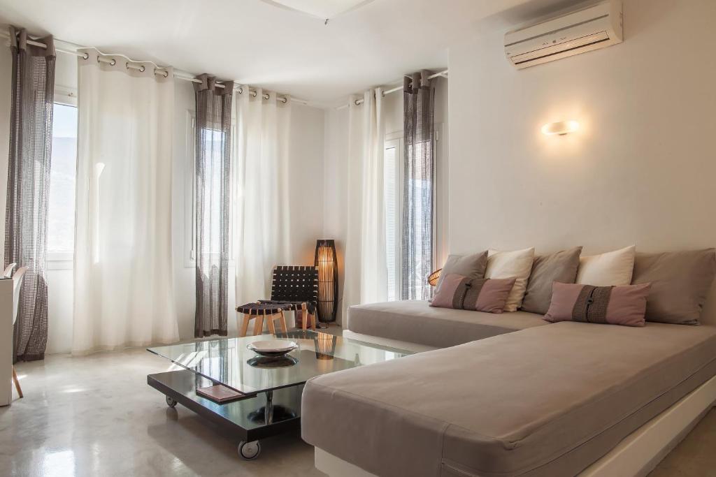 a living room with a couch and a glass table at Edem Suites in Andros