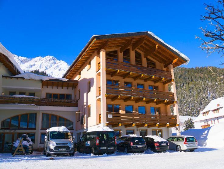 un grande edificio con macchine parcheggiate di fronte di Apart Ehart a Sankt Anton am Arlberg