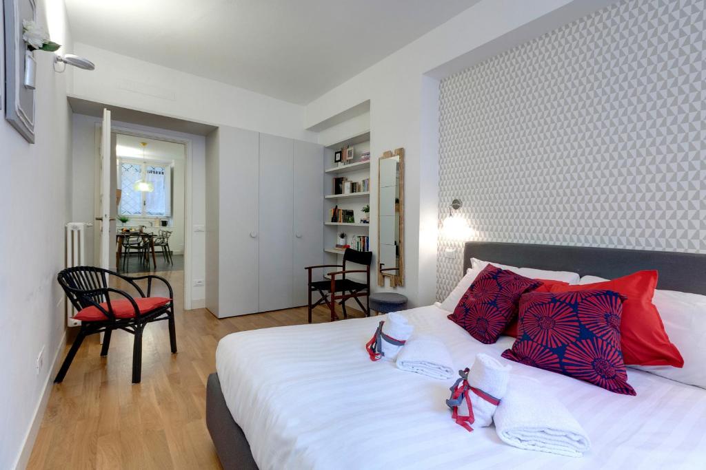 sypialnia z dużym białym łóżkiem z czerwonymi poduszkami w obiekcie Costa San Giorgio Apartment by Mamo Florence we Florencji