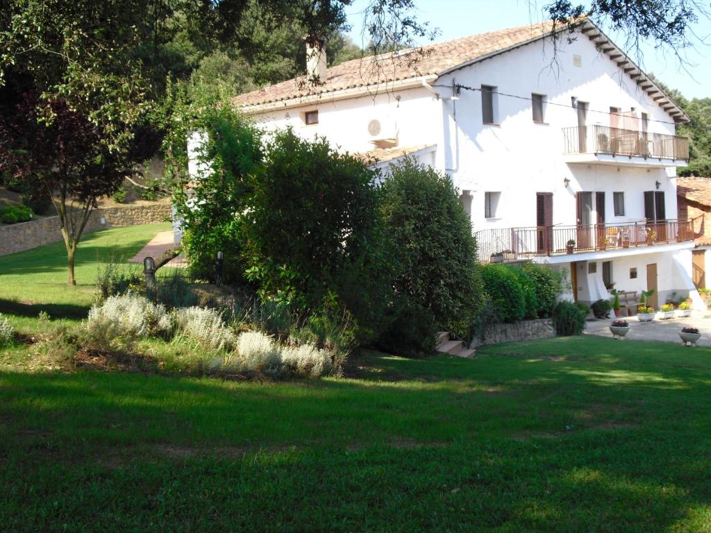 una gran casa blanca con un patio verde en Allotjaments Mas Rafalot, en Bas