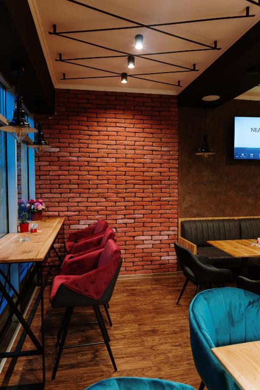 a restaurant with a brick wall and tables and chairs at Boutique Hotel Nea in Brčko