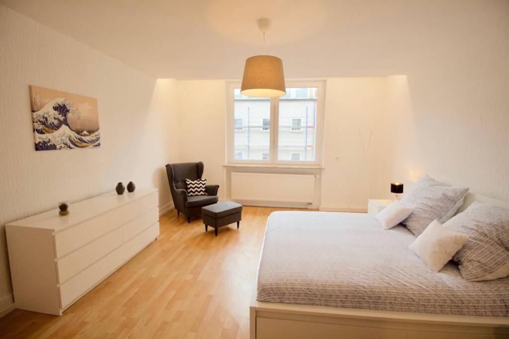 a bedroom with a bed and a chair and a window at Fantastic Apartment in Enchanting Neighbourhood in Ludwigshafen am Rhein