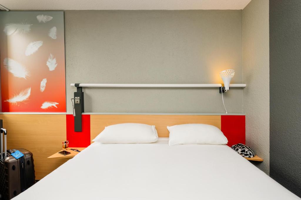 Un pat sau paturi într-o cameră la ibis Longwy Mexy