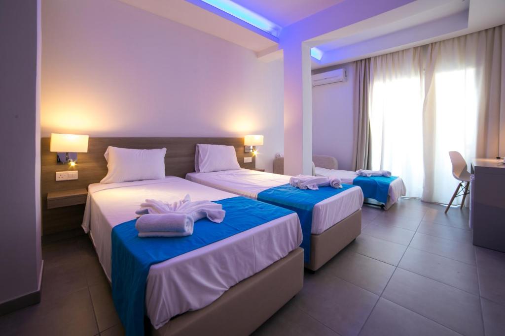 a hotel room with two beds with towels on them at Flora Maria Hotel in Ayia Napa