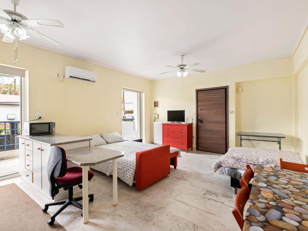 ein Schlafzimmer mit einem Bett, einem Schreibtisch und einem Bett sowie ein Zimmer in der Unterkunft Homely Apartment in Piraeus with Balcony in Athen