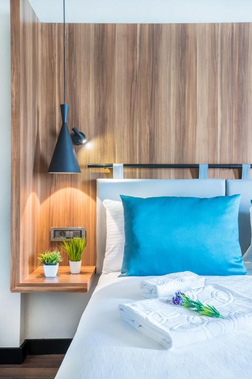 a bedroom with a blue bed with a wooden wall at Signature Ortahisar Hotel & SPA in Ürgüp
