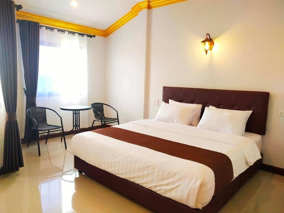 a bedroom with a large bed and a table at อันตงเพลส Anton place in Ban Pa Ngiu
