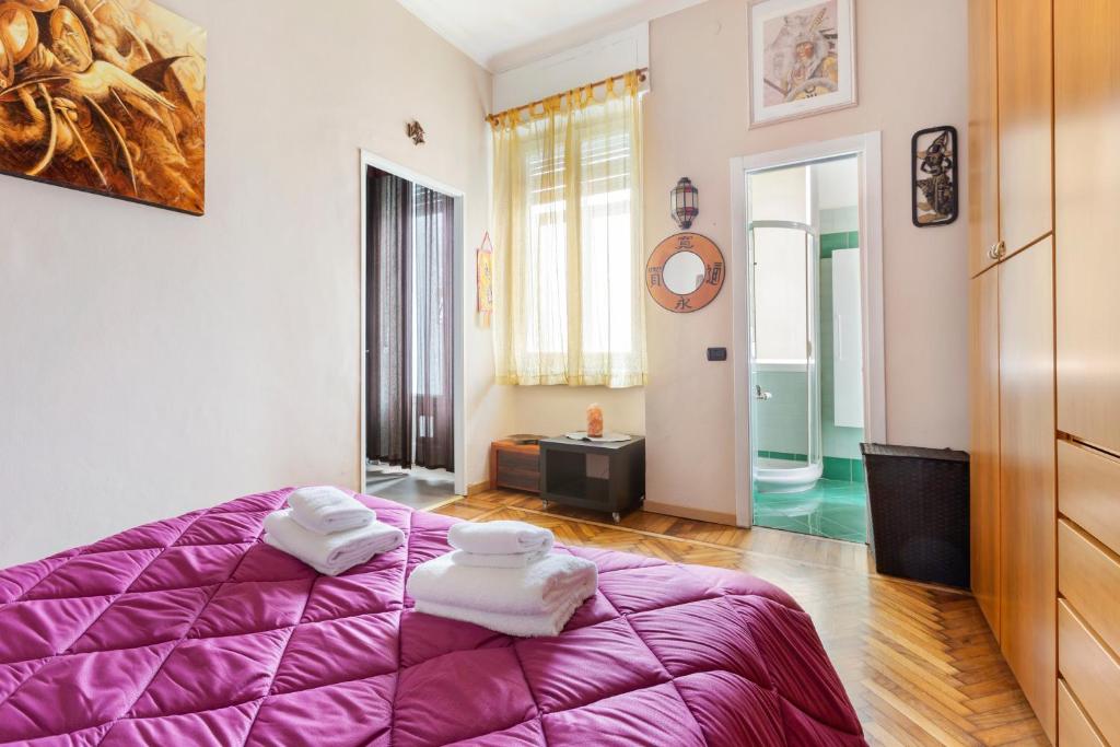 米蘭的住宿－Gambara Cosy Apartment，一间卧室配有一张紫色床和毛巾
