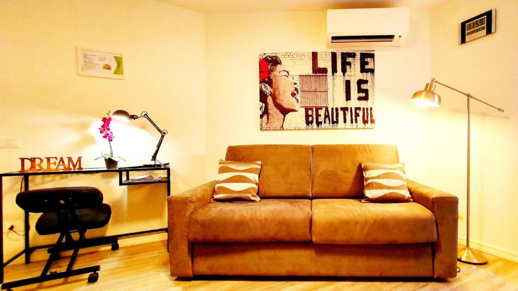 un soggiorno con divano marrone e scrivania di GUEST HOUSE MONTEGRAPPA a Reggio Emilia