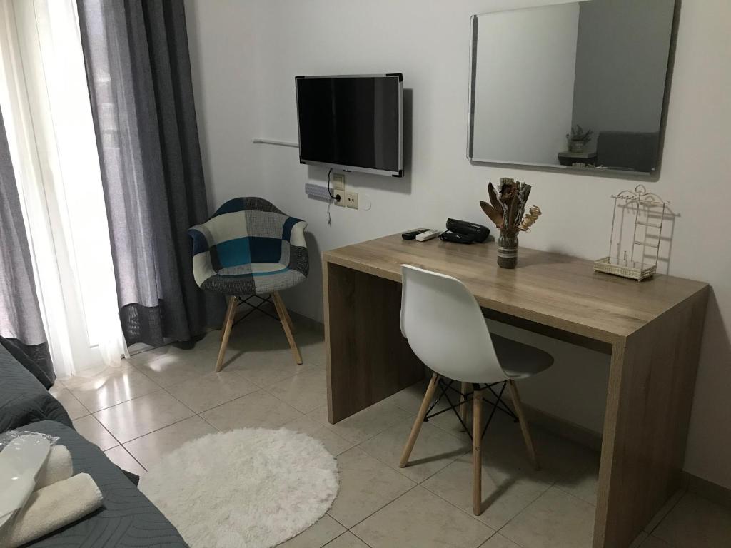a room with a desk with a tv and a chair at Heaven Studios & Apartments in Stalís