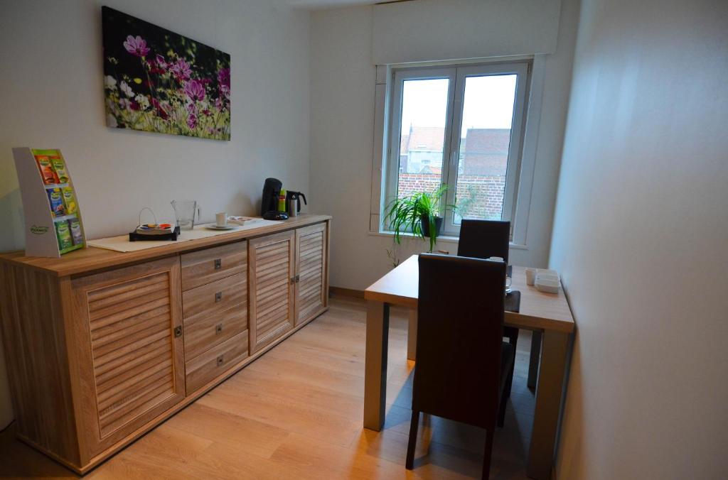 Cette chambre comprend un bureau, une table et une fenêtre. dans l'établissement B&B Het Houten Paard, à Ypres