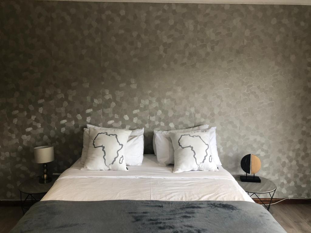 a bed with white sheets and pillows in a bedroom at Number Six in Durban