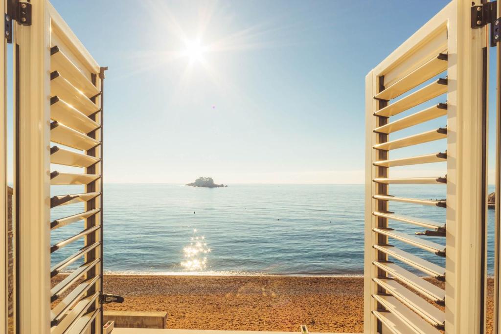 a view of the ocean through a sliding door at Apartments LIDO Petrovac in Petrovac na Moru