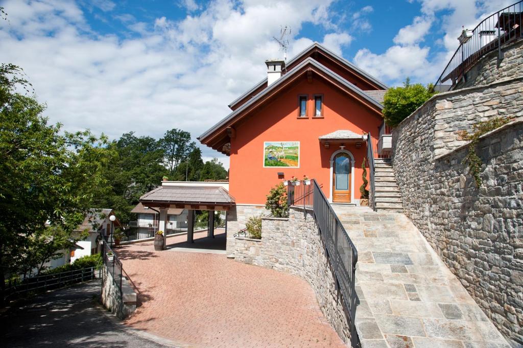 uma grande casa laranja com uma parede de pedra em B&B Al Sasso em Toceno