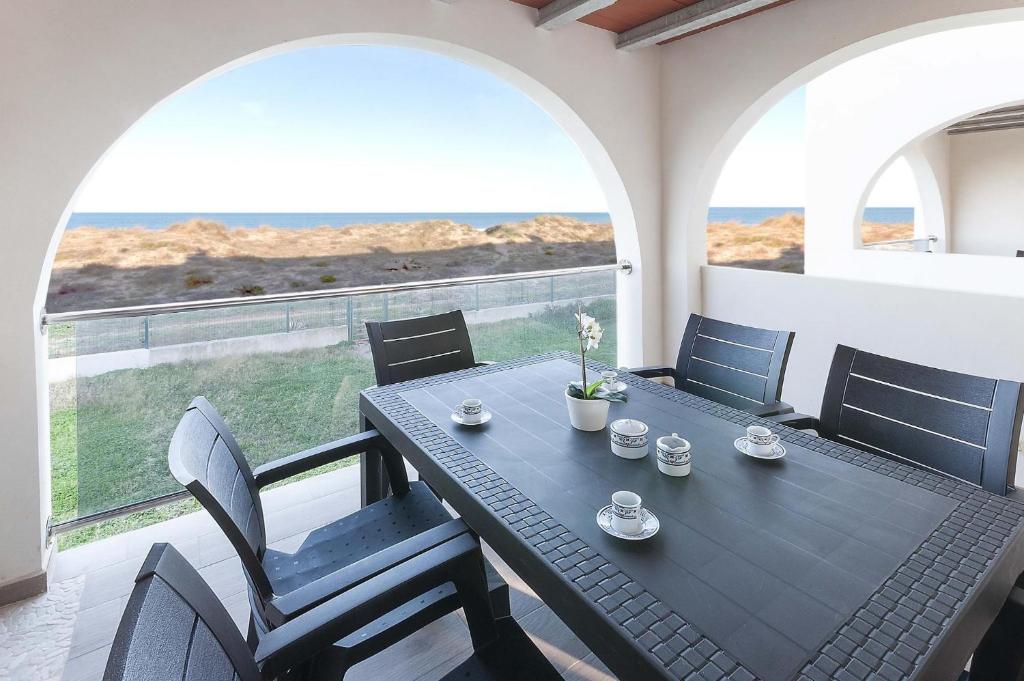 a black table and chairs on a balcony with a view of the ocean at La Mar de Olas in Oliva