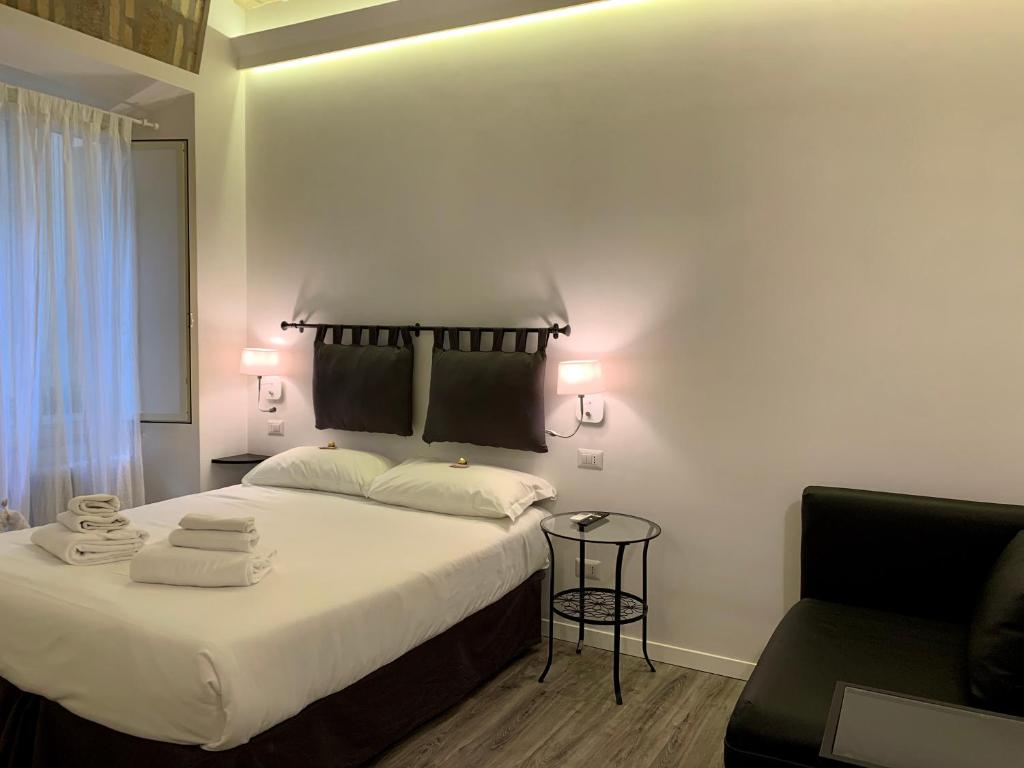 een slaapkamer met een groot bed en 2 handdoeken bij Luxury rooms near Colosseum in Rome