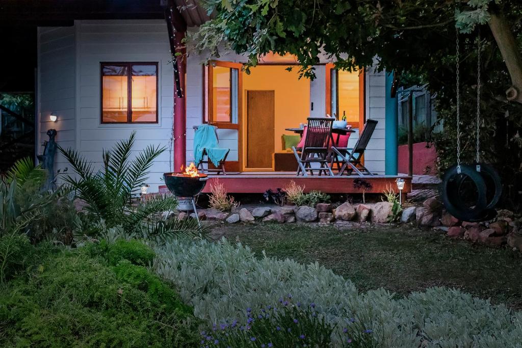 a house with a porch with a table and chairs at Mountain View Cabana in Kommetjie