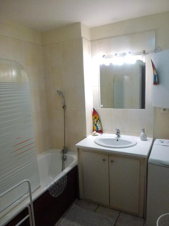 a bathroom with a sink and a tub and a mirror at Central Montgaillard in Saint-Denis