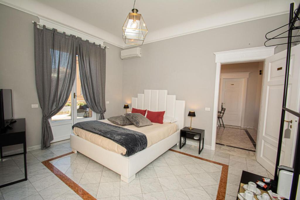 een witte slaapkamer met een bed en een raam bij Compasso Suites in Viterbo