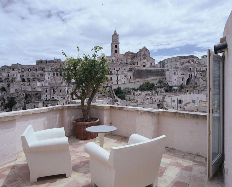 a white chair sitting in front of a large window at Hotel Sassi in Matera