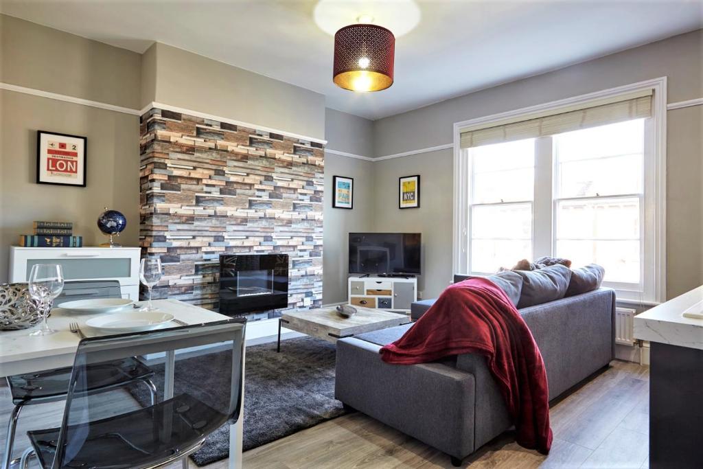 een woonkamer met een bank en een open haard bij The Sunningdale - Your Apartment in Bristol