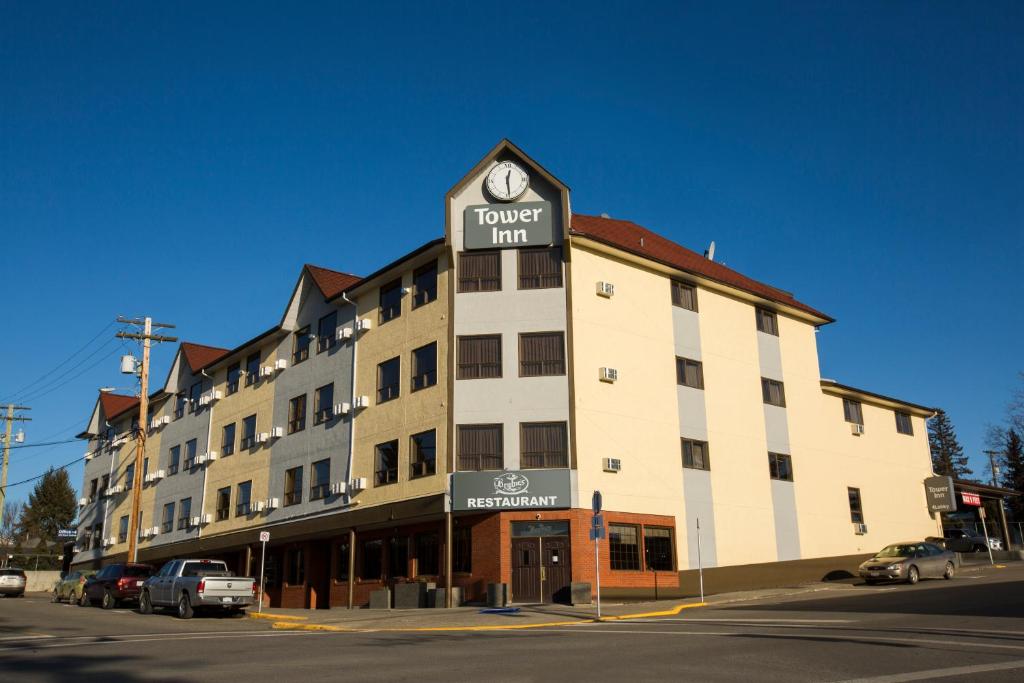 a hotel inn with a clock on top of it at Tower Inn & Suites in Quesnel